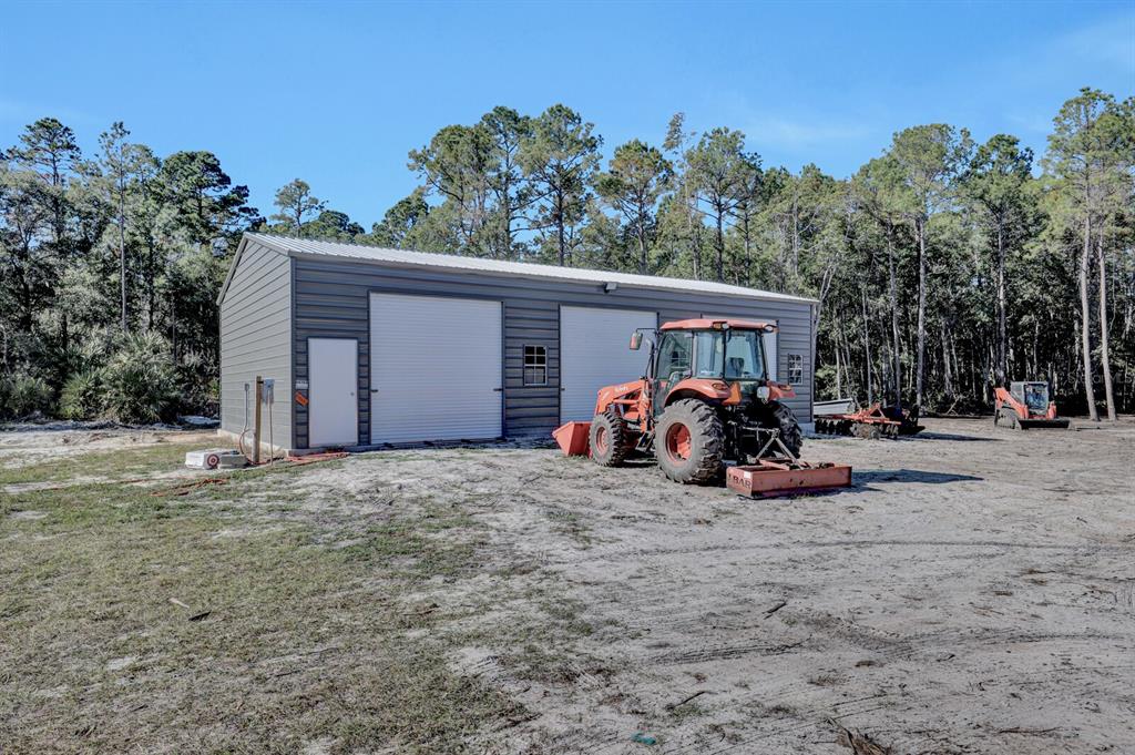 141 Woods Road San Mateo, FL 32187 - Photo 54 of 66 a view of a bike garage next to a yard