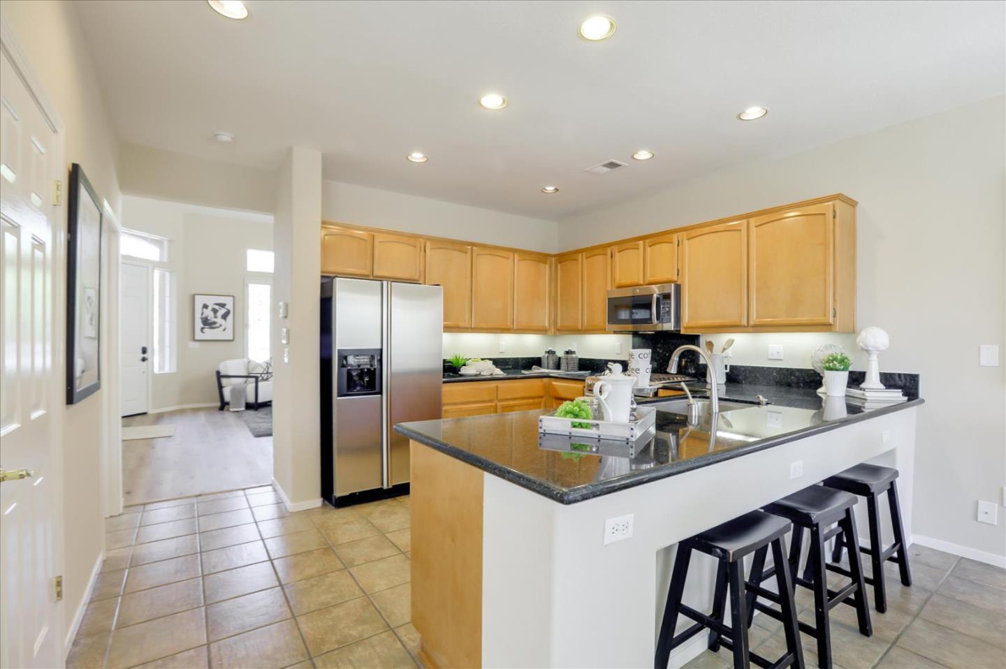 546 Esplanade Lane San Jose, CA 95138 - Photo 6 of 24 a kitchen with stainless steel appliances granite countertop a refrigerator a sink a stove a dining table and chairs