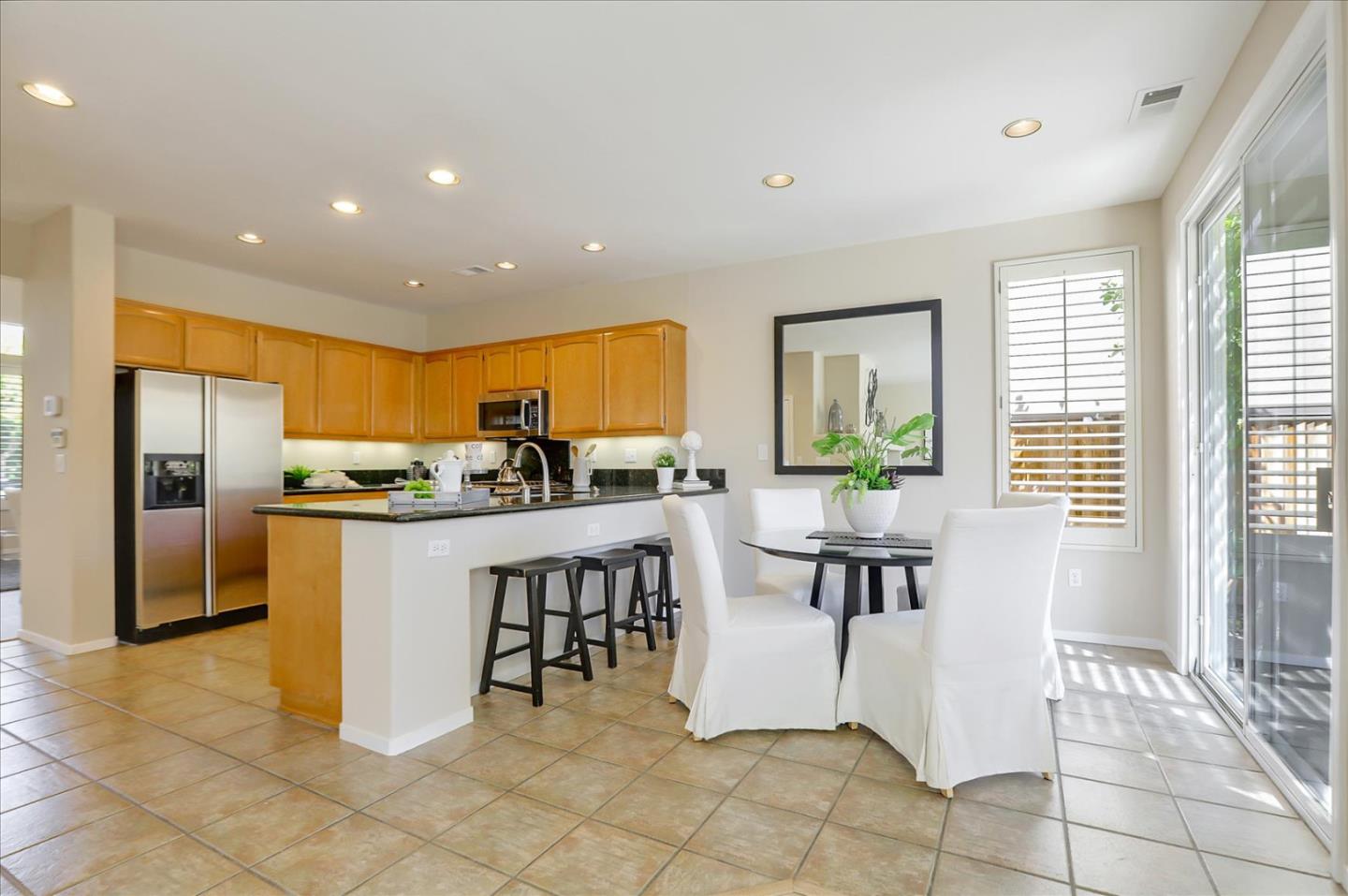 546 Esplanade Lane San Jose, CA 95138 - Photo 7 of 24 a kitchen with stainless steel appliances a dining table chairs and a refrigerator