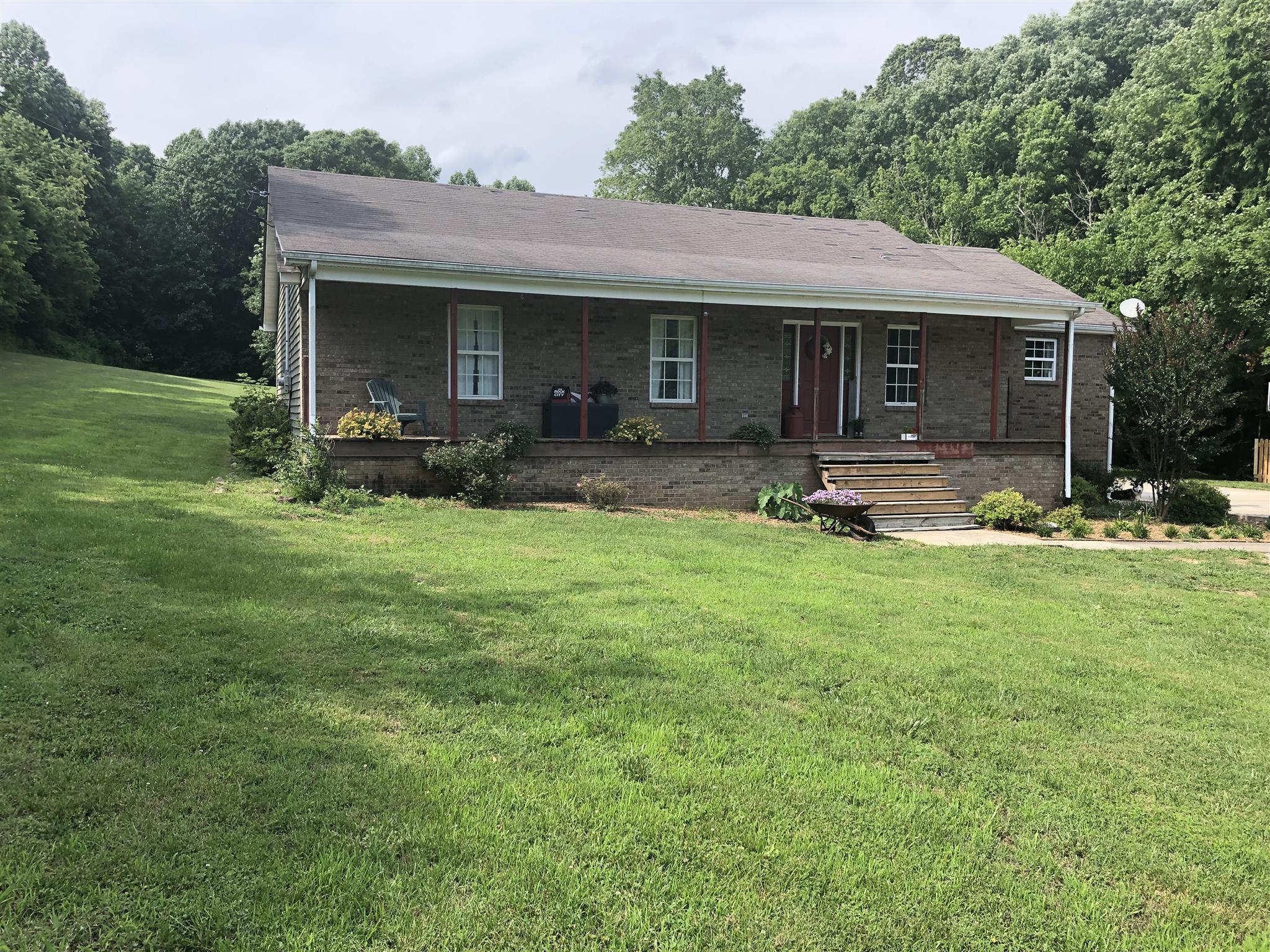 1073 Ervin Pace Road Chapmansboro, TN 37035 - Photo 1 of 19 Close-up of front porch and beautiful landscaping and flowers.
