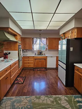 a kitchen with wooden floors and wooden cabinets