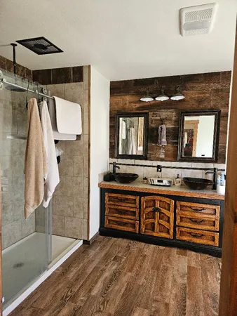a en suite bathroom with a double vanity sink and a mirror