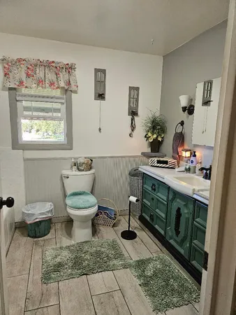 a bathroom with a toilet sink and mirror