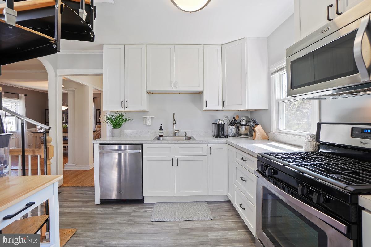 4206 Dahill Road Silver Spring, MD 20906 - Photo 17 of 33 a kitchen with cabinets stainless steel appliances and wooden floor