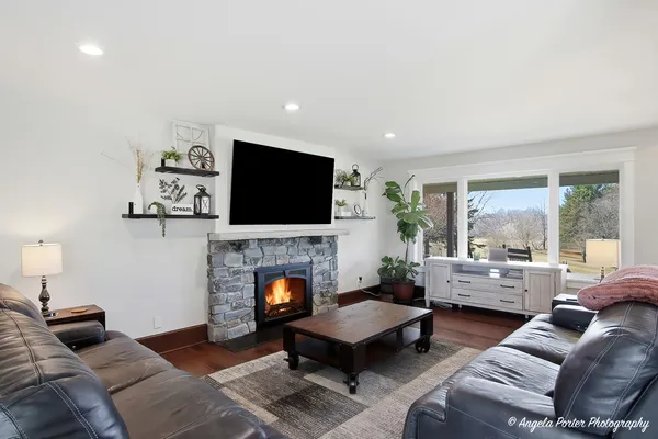 a living room with furniture a flat screen tv and a fireplace