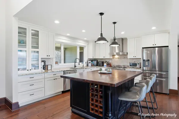 a kitchen with center island white cabinets and stainless steel appliances