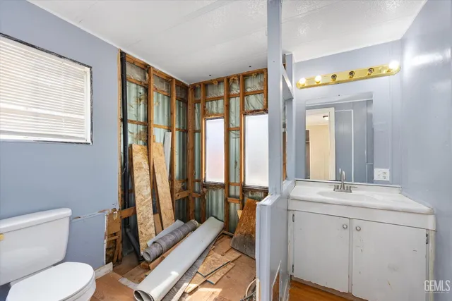 a bathroom with a granite countertop sink a toilet and a mirror