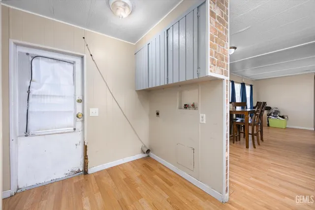 a view of a hallway to a room with wooden floor and staircase