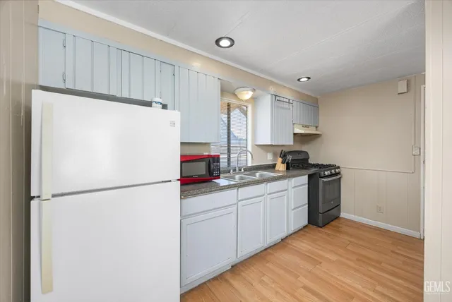 a kitchen with a refrigerator a sink and cabinets