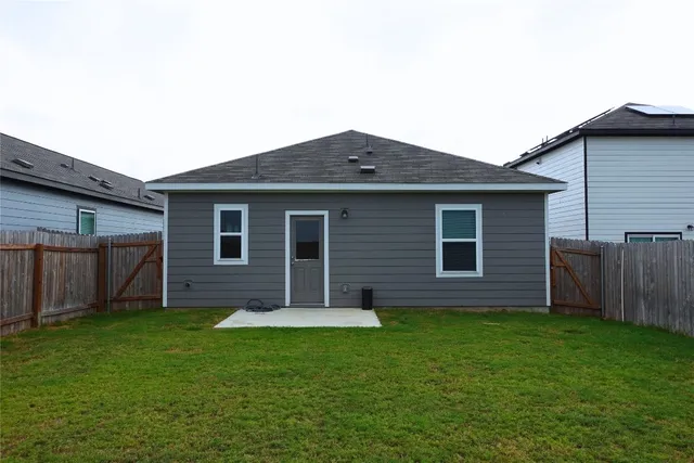a backyard of a house with potted plants and wooden fence