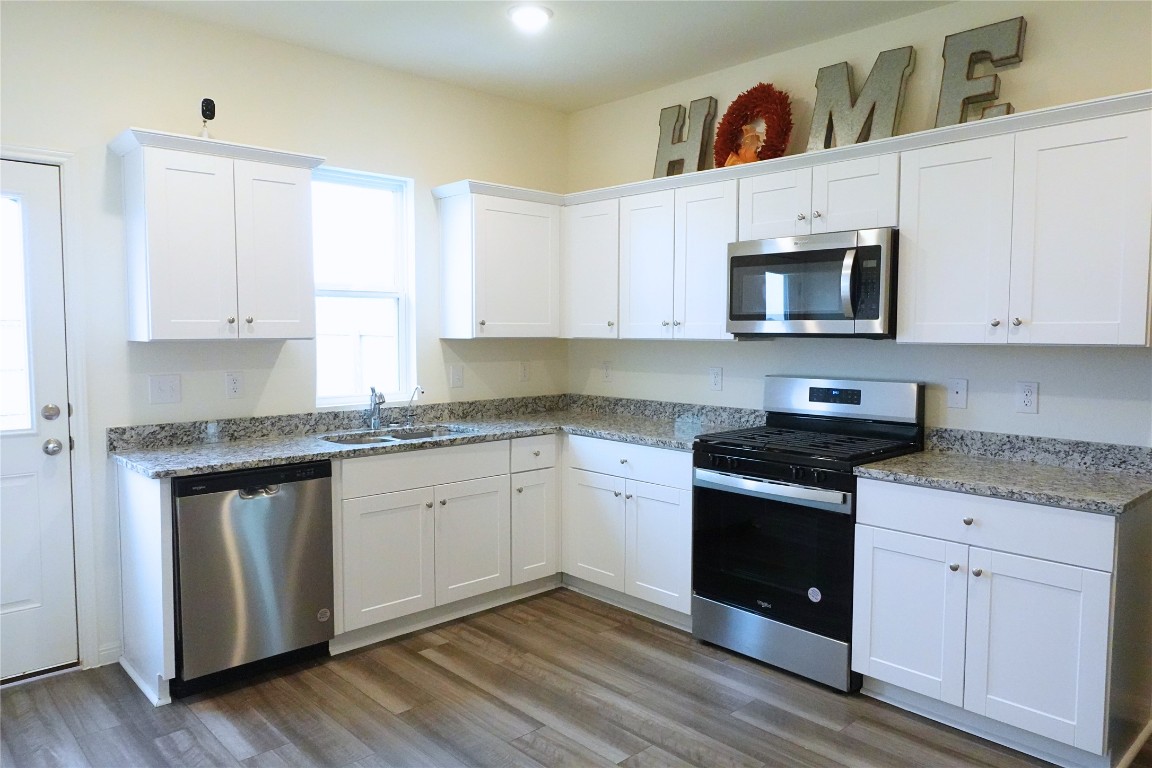402 Plateau Street Maxwell, TX 78656 - Photo 4 of 18 a kitchen with granite countertop white cabinets stainless steel appliances and a sink