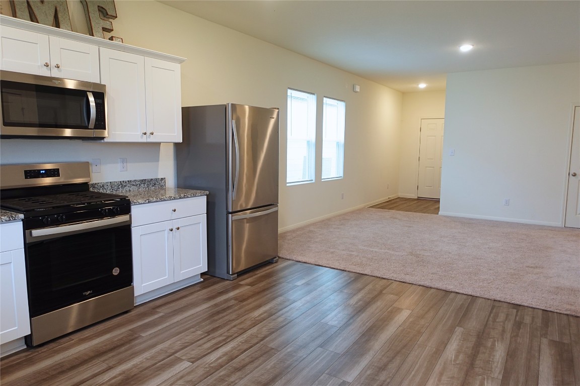 402 Plateau Street Maxwell, TX 78656 - Photo 5 of 18 a kitchen with granite countertop a stove a sink and a microwave