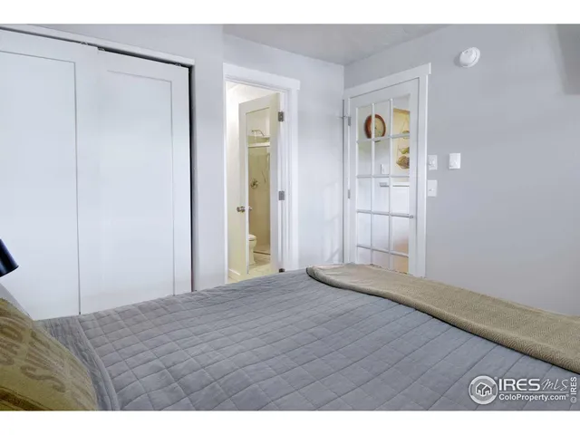 a view of an empty room with closet and wooden floor