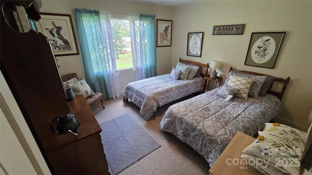 a bedroom with two beds and wooden floor