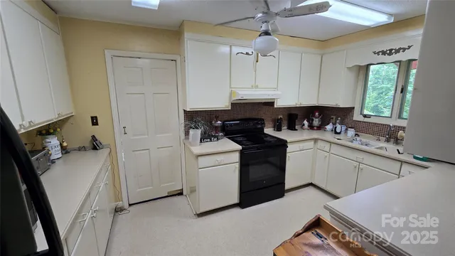 a kitchen with a sink dishwasher and white cabinets