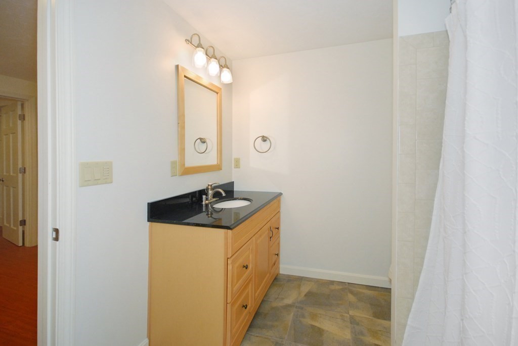 22 Taylor Road Stow, MA 01775 - Photo 25 of 32 a bathroom with a granite countertop sink and a mirror