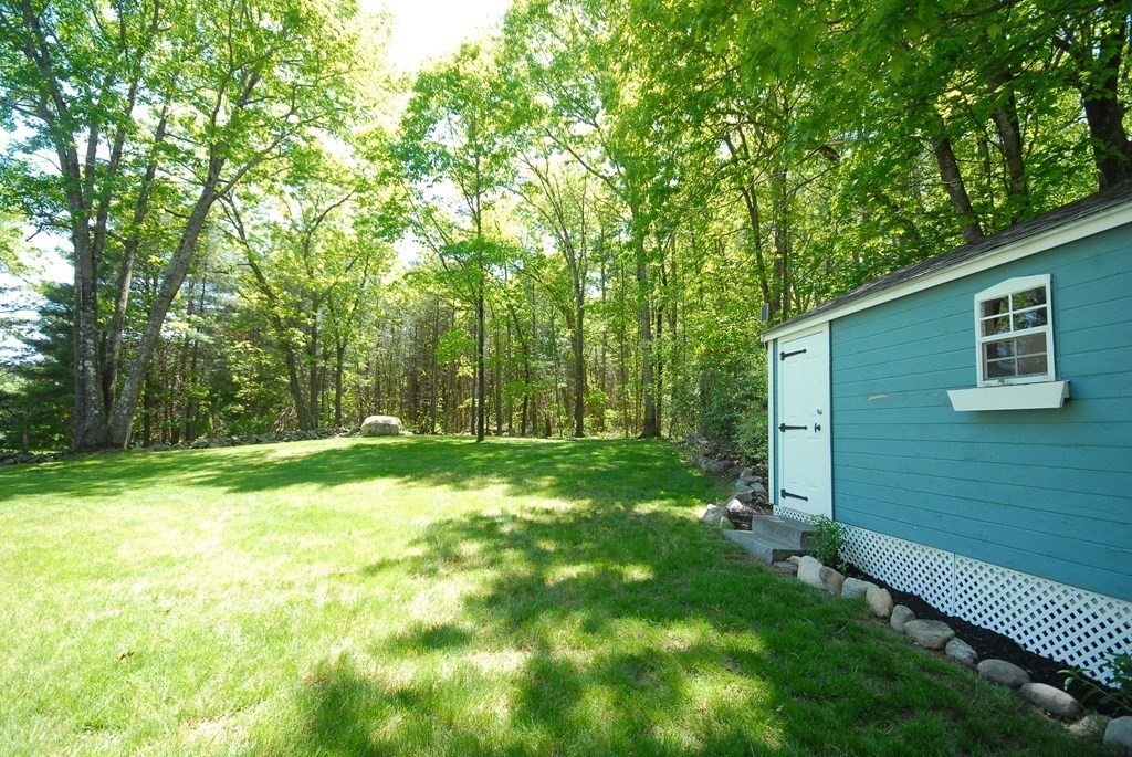22 Taylor Road Stow, MA 01775 - Photo 29 of 32 a backyard of a house with plants and large trees