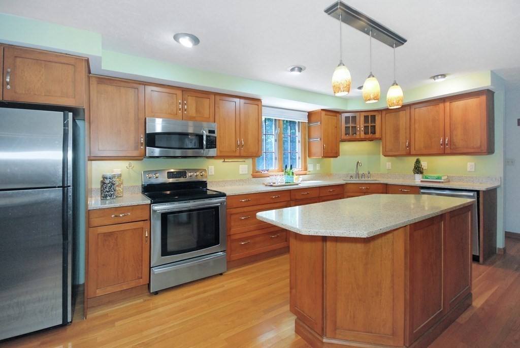 22 Taylor Road Stow, MA 01775 - Photo 9 of 32 a kitchen with stainless steel appliances granite countertop a sink a stove and a refrigerator