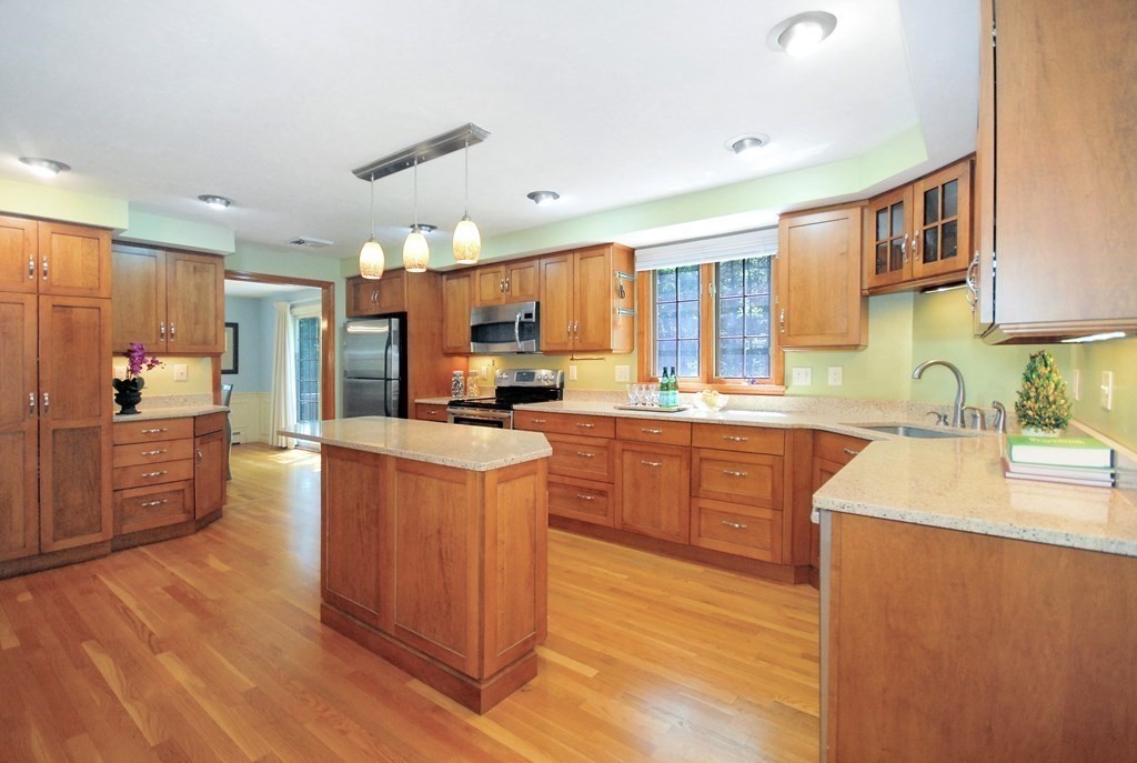 22 Taylor Road Stow, MA 01775 - Photo 10 of 32 a large kitchen with stainless steel appliances granite countertop a stove refrigerator a sink dishwasher and wooden cabinets with wooden floor