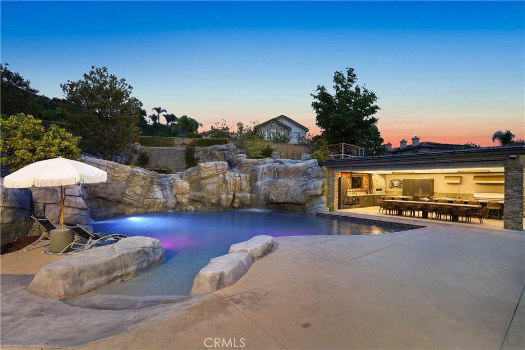 29131 Bouquet Canyon Road Silverado, CA 92676 - Photo 8 of 74 a view of a pool with table and chairs a fire pit