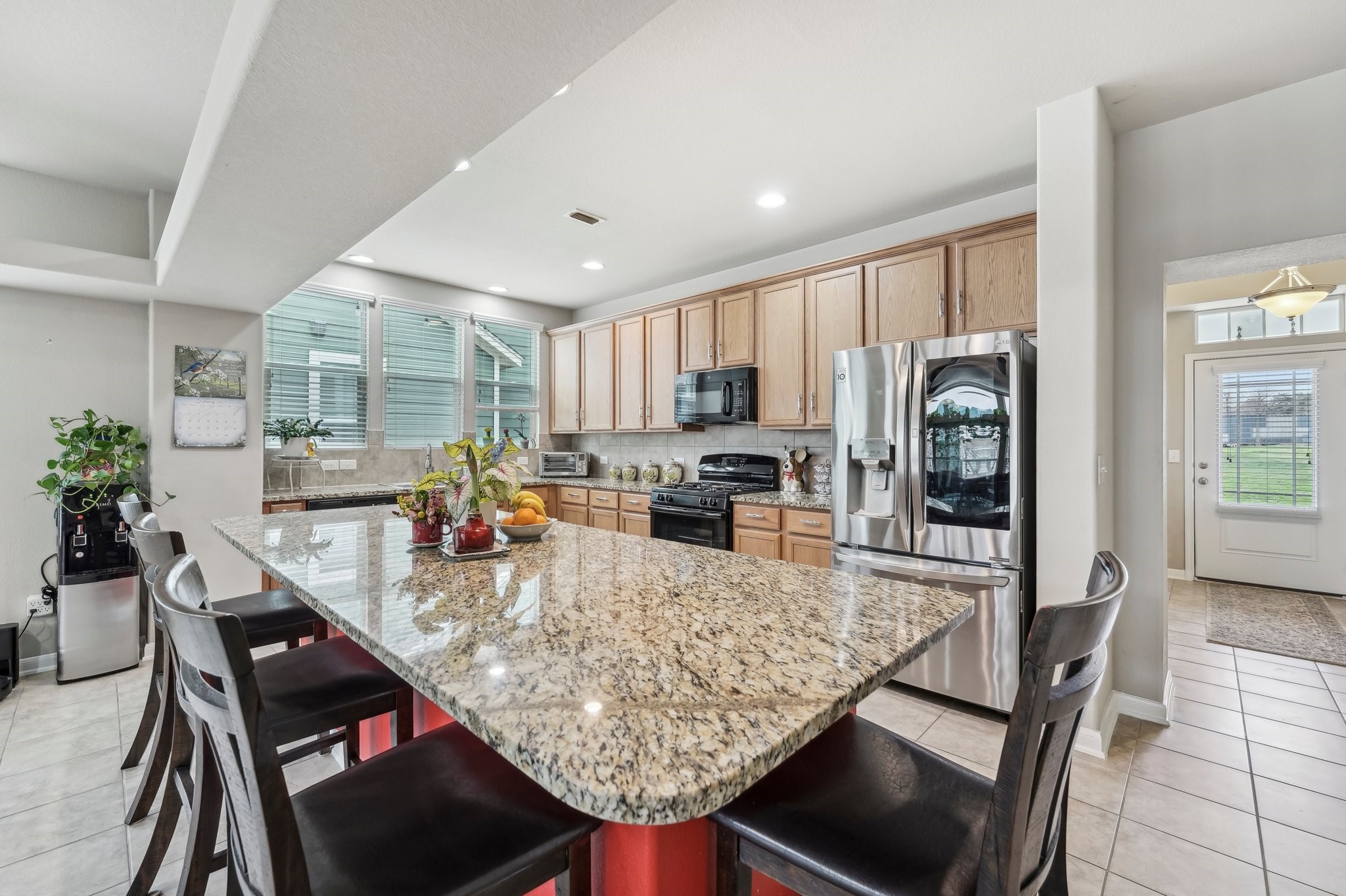 1373 Nevarez Kyle, TX 78640 - Photo 7 of 38 a kitchen with stainless steel appliances granite countertop sink stove refrigerator dining table and chairs