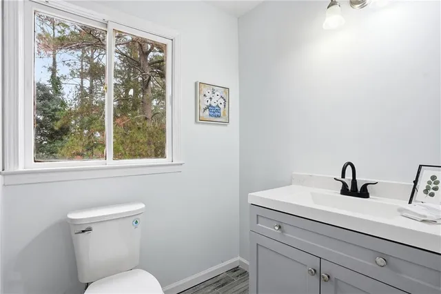 a bathroom with a toilet a sink and a window