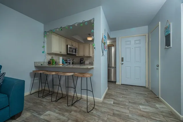 a living room with furniture and a view of kitchen