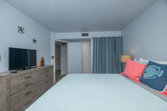 a bedroom with a bed and a flat screen tv