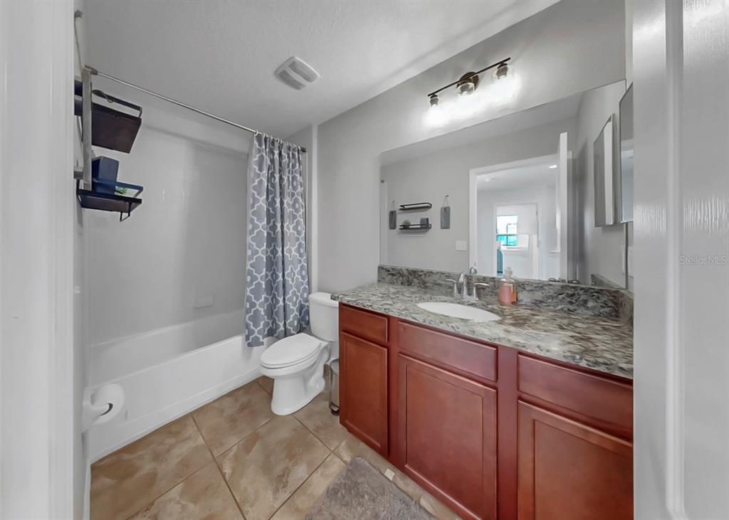 10136 Newminster Loop Ruskin, FL 33573 - Photo 12 of 64 a bathroom with a granite countertop sink toilet and shower