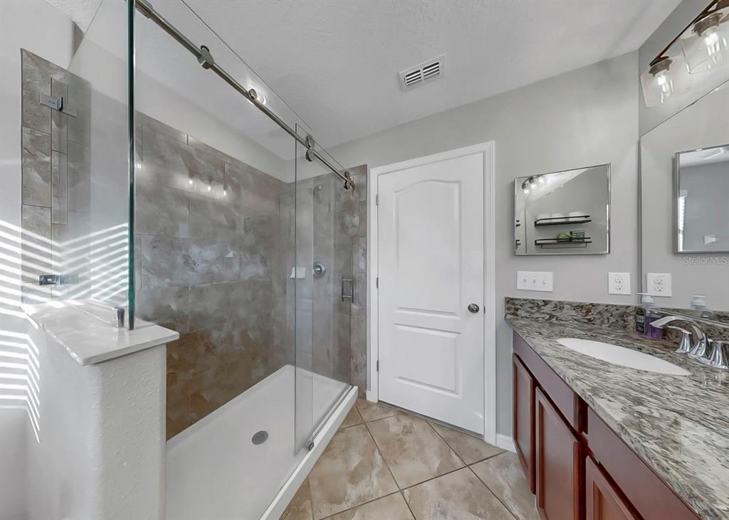 10136 Newminster Loop Ruskin, FL 33573 - Photo 28 of 64 a bathroom with a granite countertop sink a toilet and shower