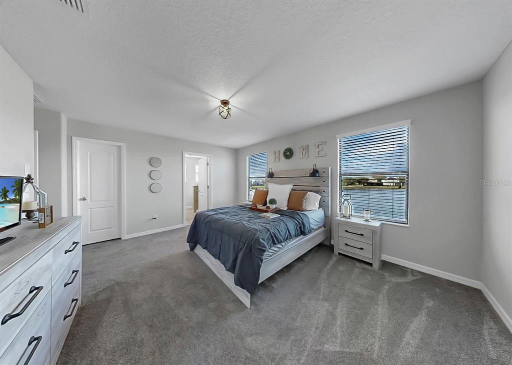 10136 Newminster Loop Ruskin, FL 33573 - Photo 29 of 64 a spacious bedroom with a bed and a window