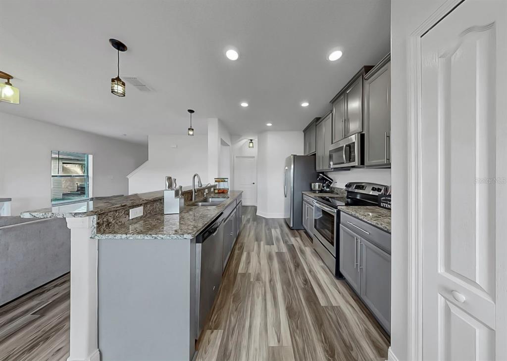 10136 Newminster Loop Ruskin, FL 33573 - Photo 33 of 64 a kitchen with granite countertop a sink stove and refrigerator