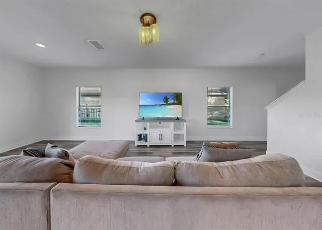 a front view of a house with a yard and potted plants