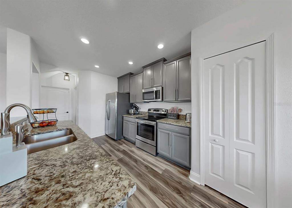 10136 Newminster Loop Ruskin, FL 33573 - Photo 44 of 64 a kitchen with stainless steel appliances granite countertop a refrigerator and a sink