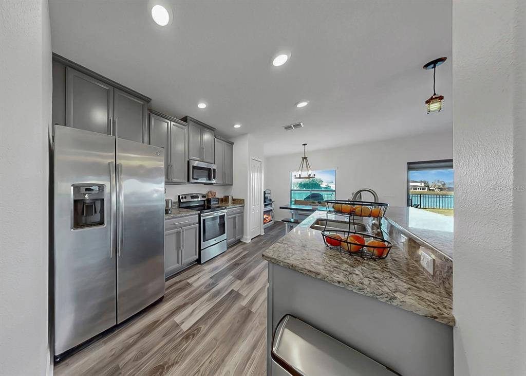 10136 Newminster Loop Ruskin, FL 33573 - Photo 45 of 64 a kitchen with stainless steel appliances a refrigerator sink and stove