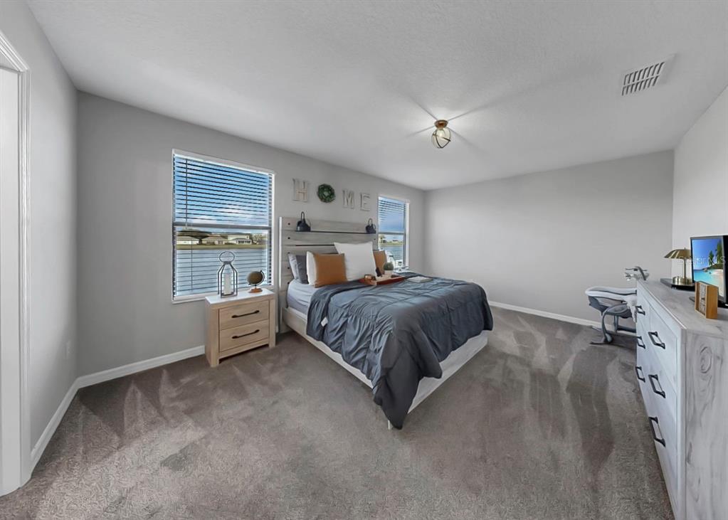 10136 Newminster Loop Ruskin, FL 33573 - Photo 8 of 64 a spacious bedroom with a bed and a window