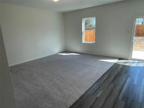 an empty room with windows and mirror