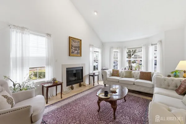 a living room with furniture a rug a window and a fireplace