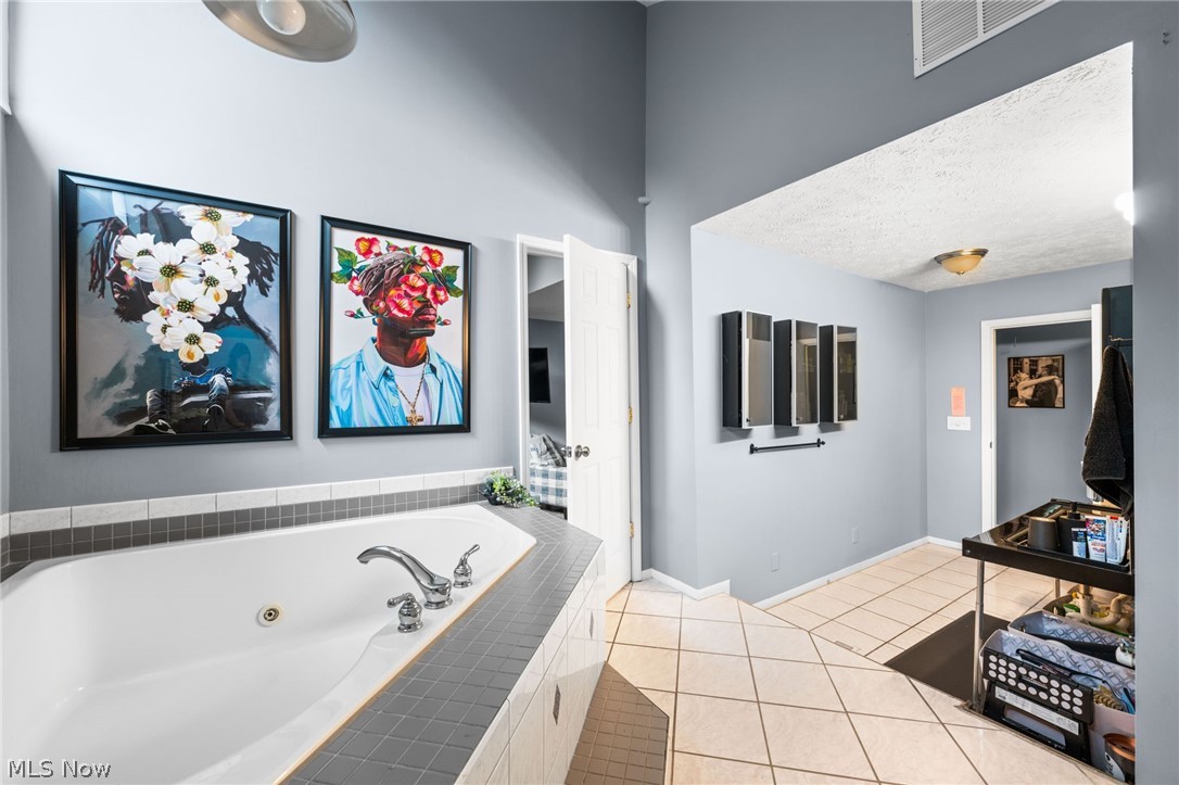 4159 Bluestone Road Cleveland, OH 44121 - Photo 29 of 42 Bathroom with tile floors, a textured ceiling, and tiled tub