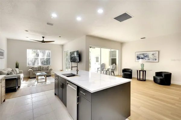 a large kitchen with a large counter top furniture a sink a counter space and living room view