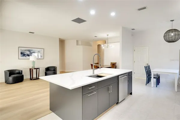 a kitchen with a sink a counter space and living room