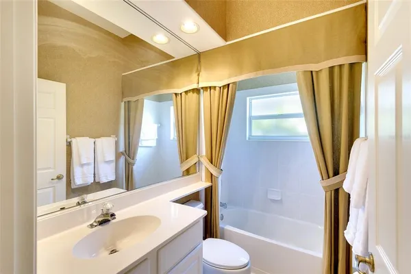 a bathroom with a sink a toilet a tub and shower