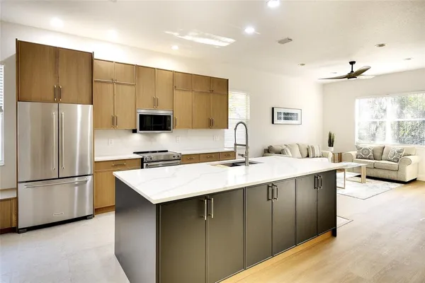 a kitchen with stainless steel appliances granite countertop a sink stove and refrigerator