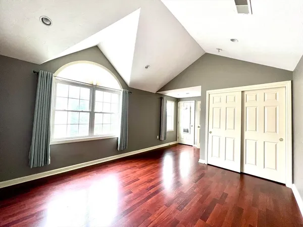 an empty room with wooden floor and windows