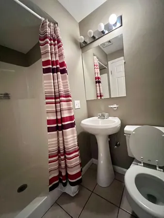 a bathroom with a sink toilet and mirror