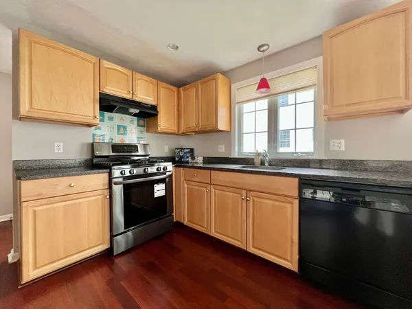 a kitchen with stainless steel appliances granite countertop a stove a sink and a microwave