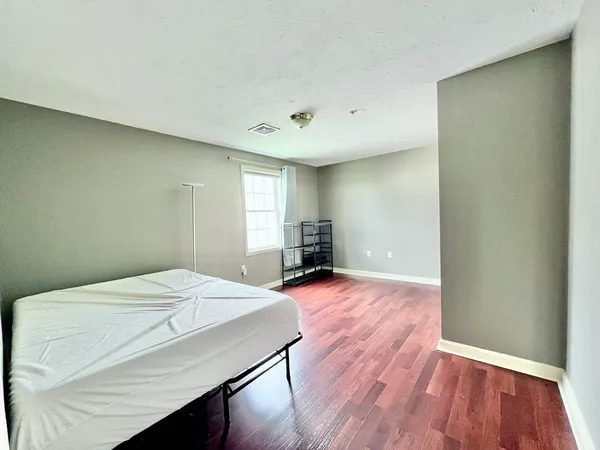 a room with a bed and wooden floor