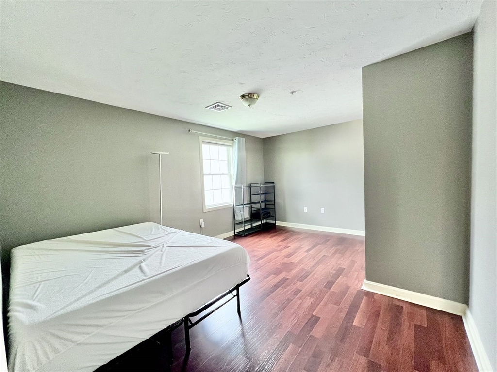 1005 Trapelo Road, Unit 3 Waltham, MA 02452 - Photo 9 of 19 a room with a bed and wooden floor