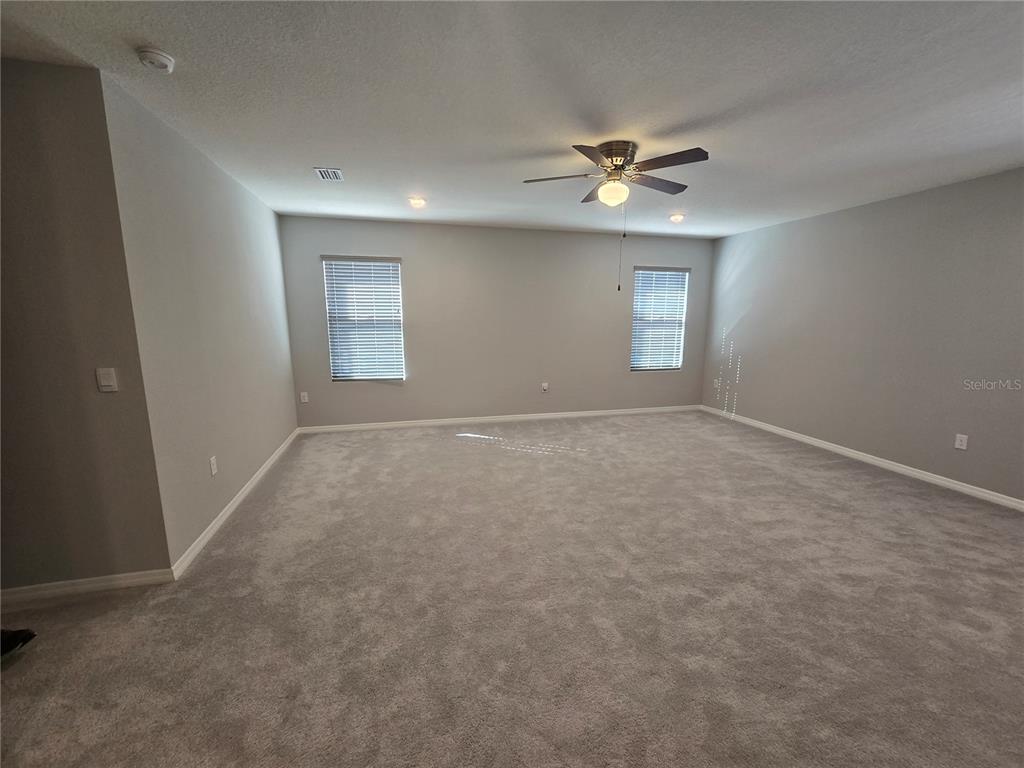 5846 Southwest 80th Lane Ocala, FL 34476 - Photo 20 of 27 a view of an empty room with a ceiling fan and a window