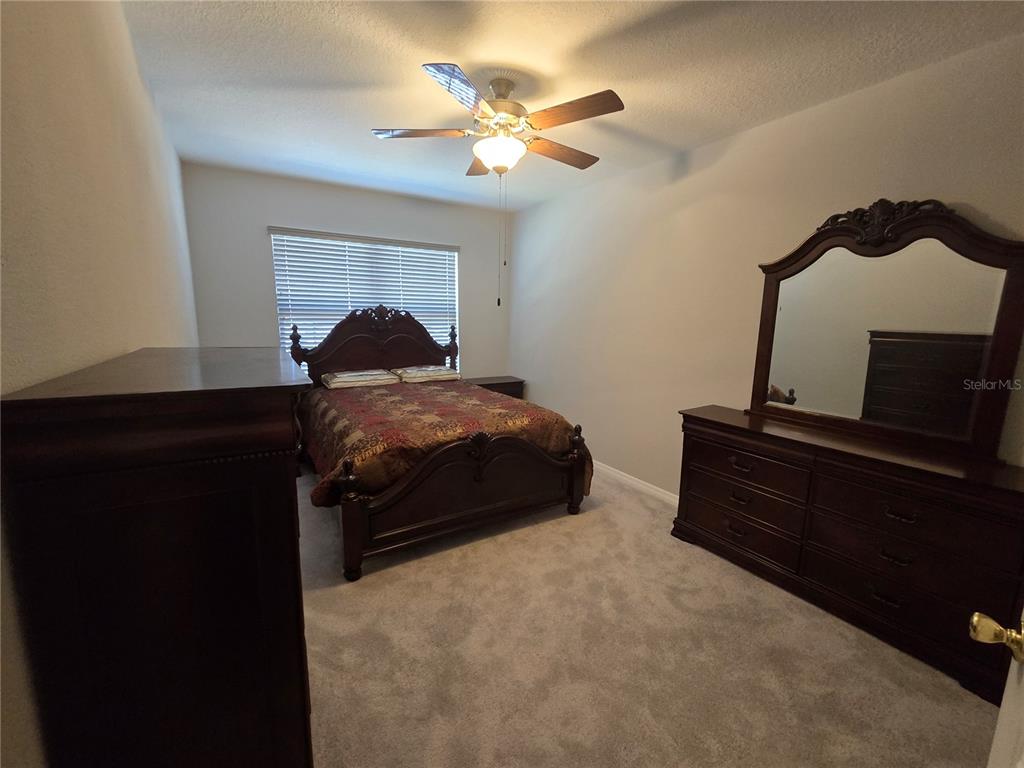 5846 Southwest 80th Lane Ocala, FL 34476 - Photo 24 of 27 a bedroom with a bed and a ceiling fan